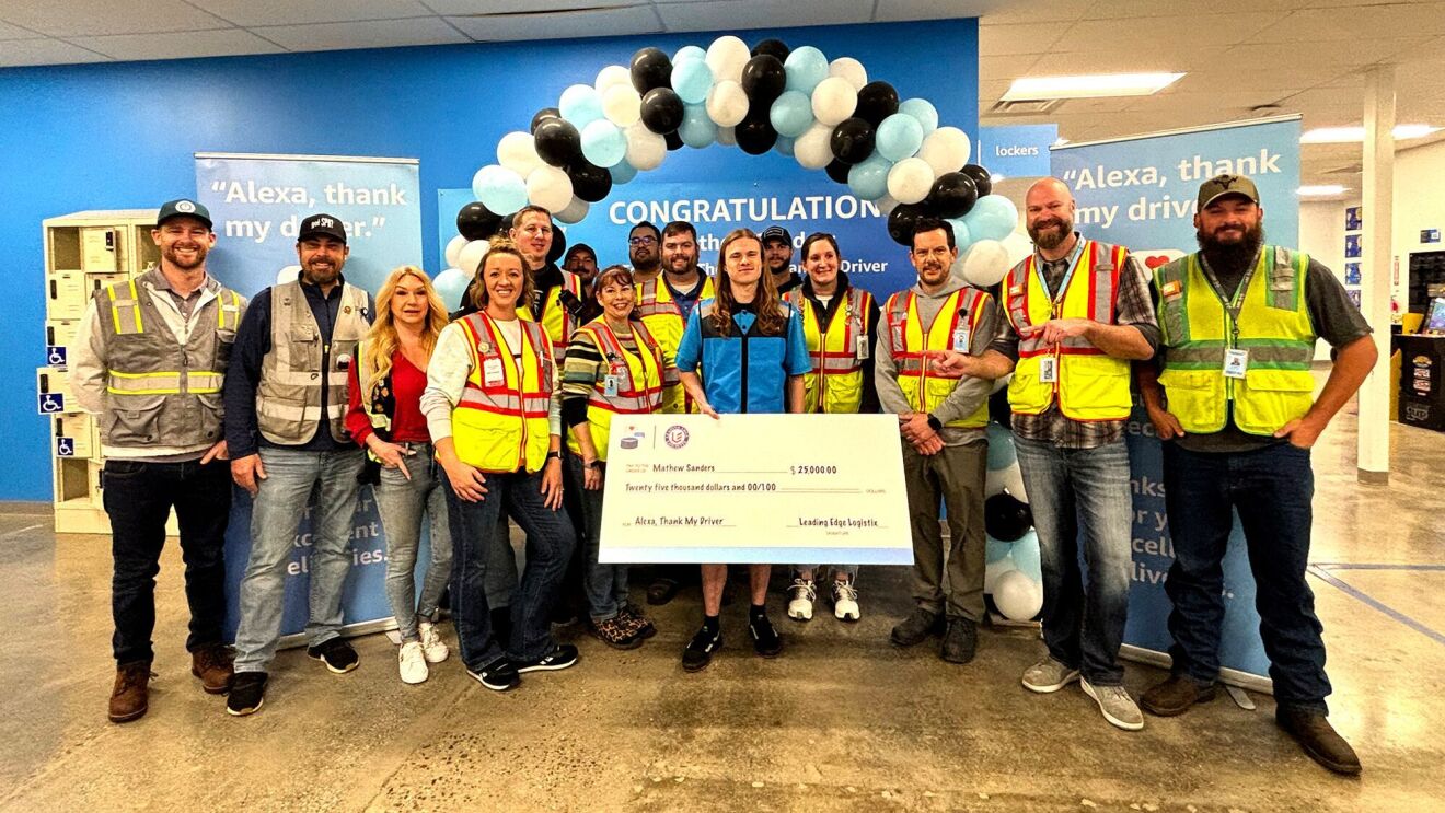 'Alexa, thank my driver' winners hold their winnings in a big check while they stand next to colleagues.