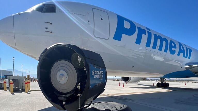 An image of a power breezer in front of a Prime Air airplane.