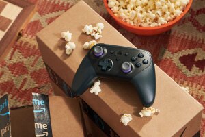 An image of two Amazon boxes, a black Luna remote and a red bowl of popcorn. 