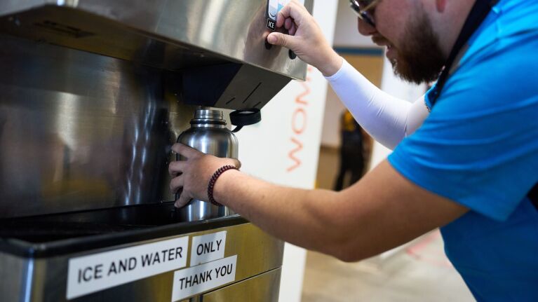 An image of an Amazon delivery driver filling a water bottle.