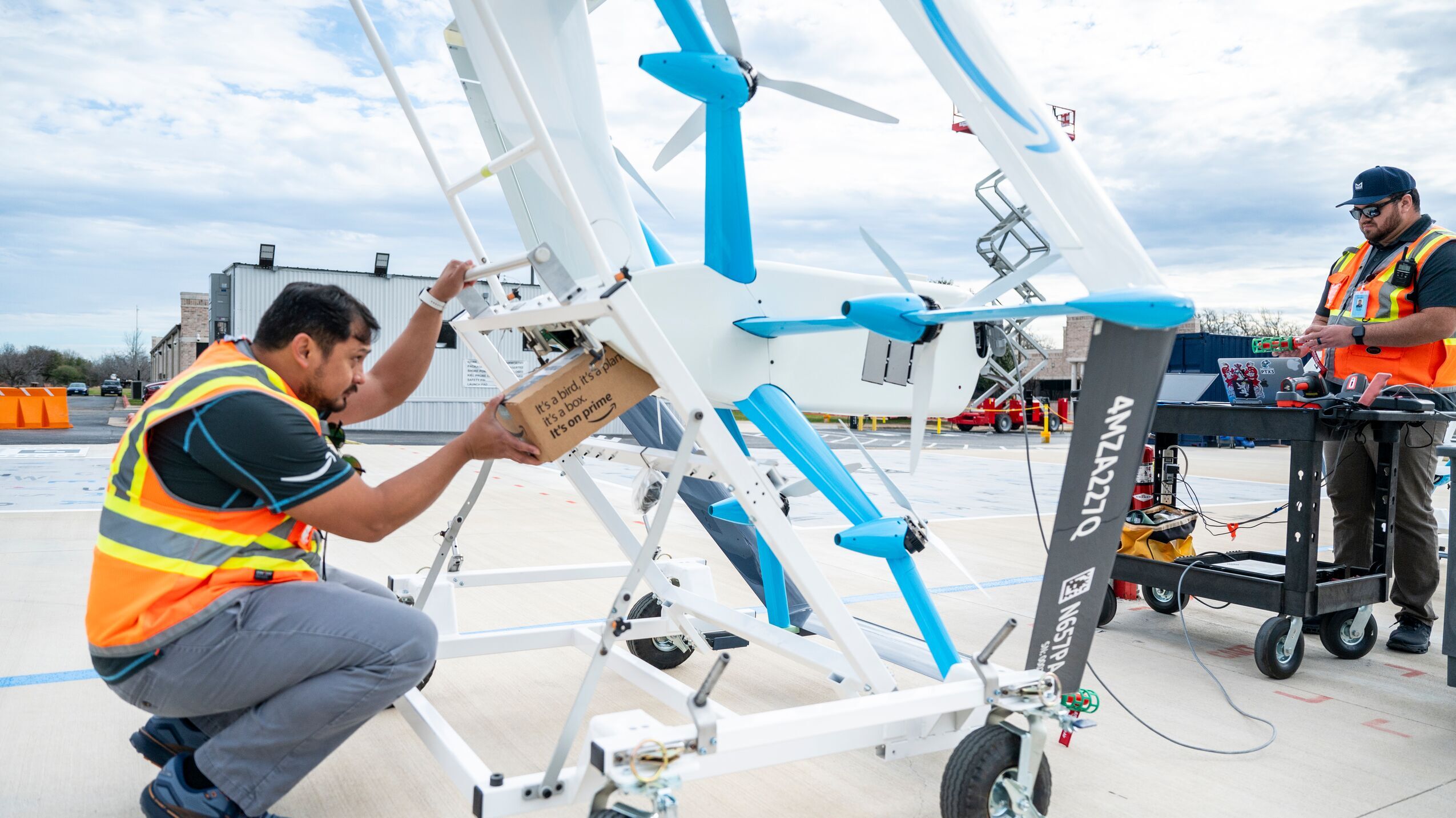 An employee loads a package into a delivery drone before it takes flight