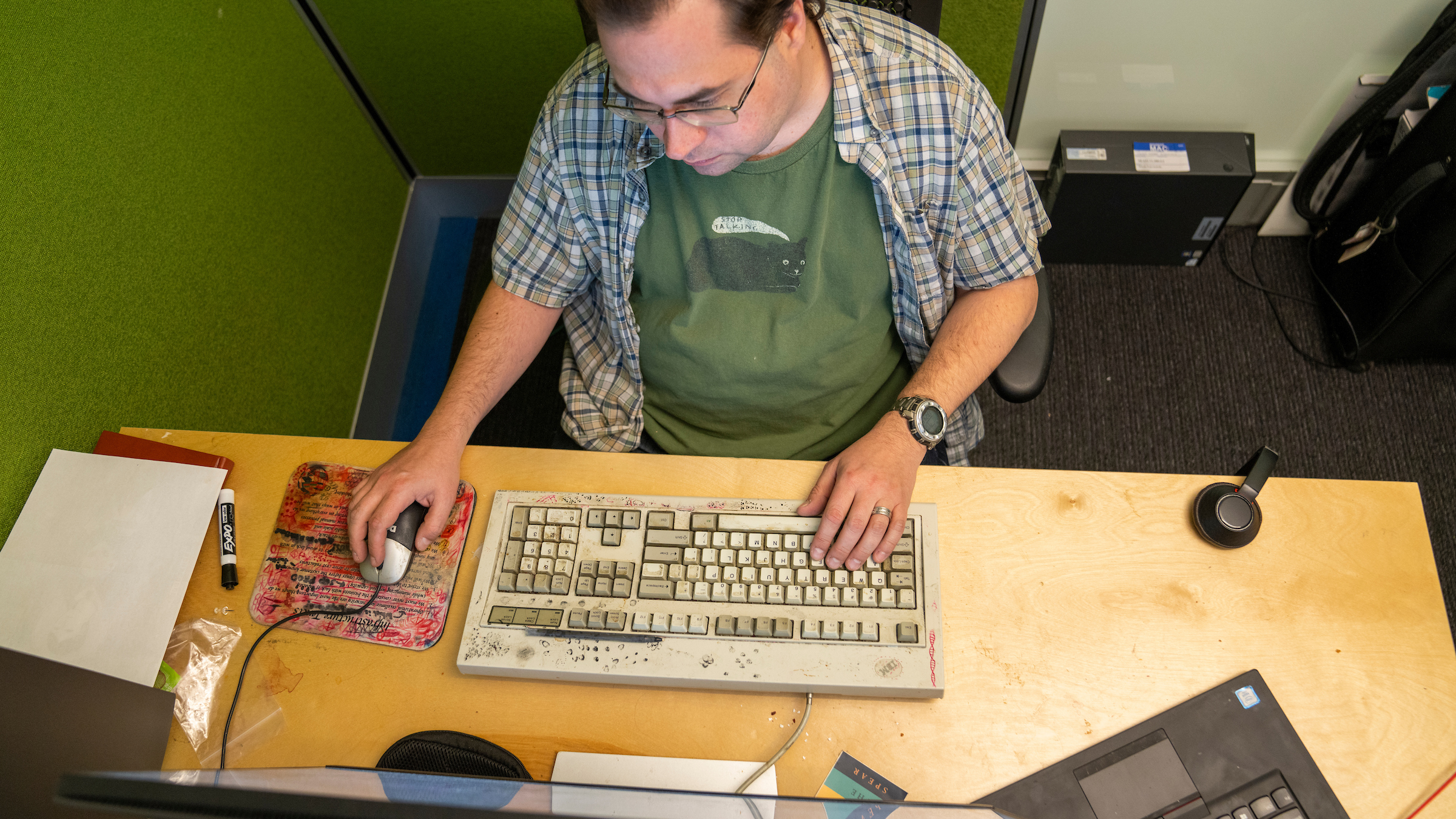 A photo of AWS VP and Distinguished Engineer Tom Scholl working at his desk, monitoring spikes in internet traffic.